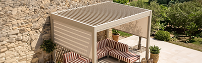 pergola bioclimatique autoportée en aluminium beige couvrant un salon de jardin modulable