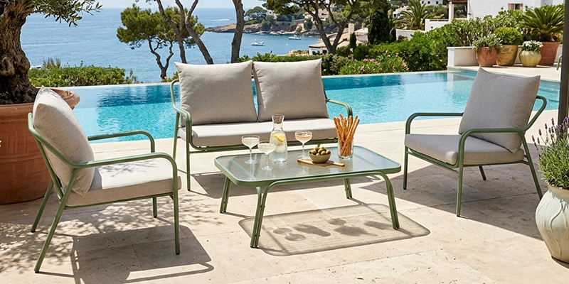 Salon de jardin bas en aluminium 4 places avec table basse proche d'une piscine