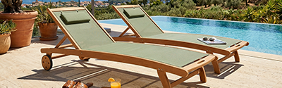 bains de soleil en bois inclinables avec roues coloris vert sauge au bord d'une belle piscine